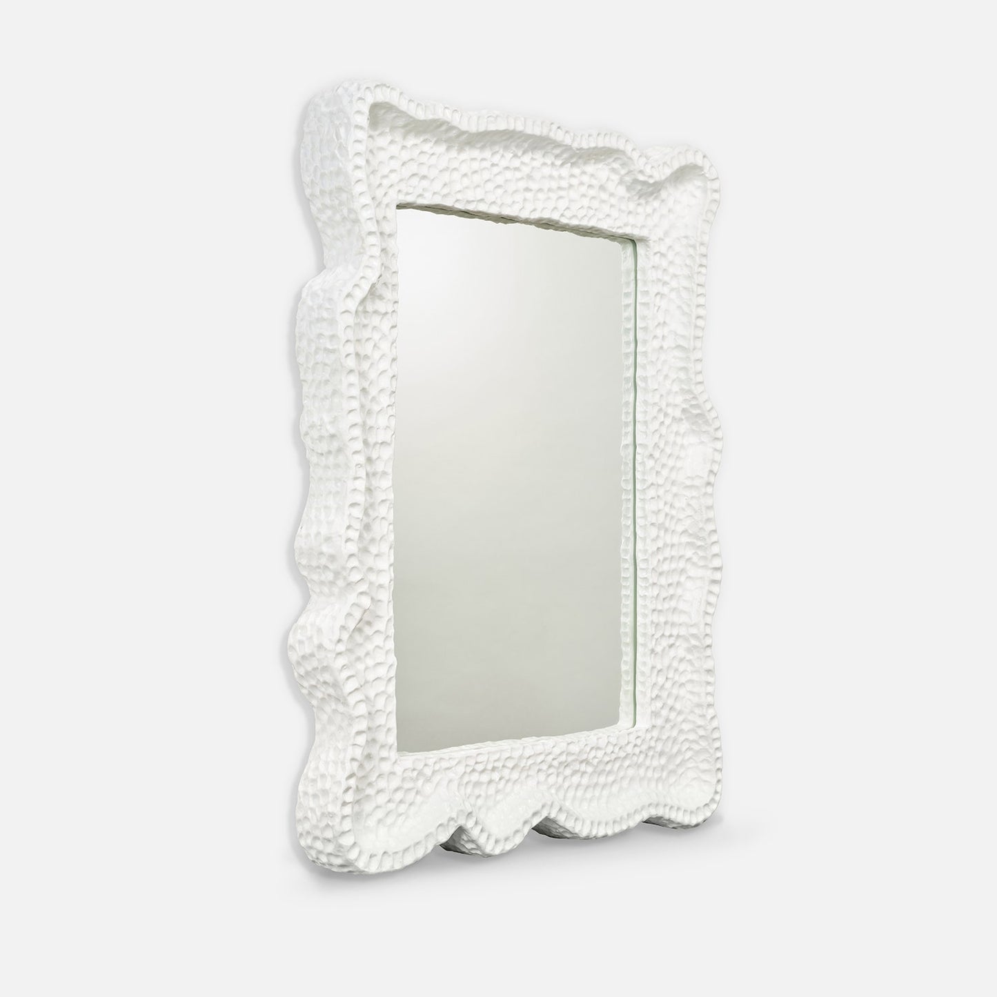 Decorative mirror with a textured white frame on a light gray background