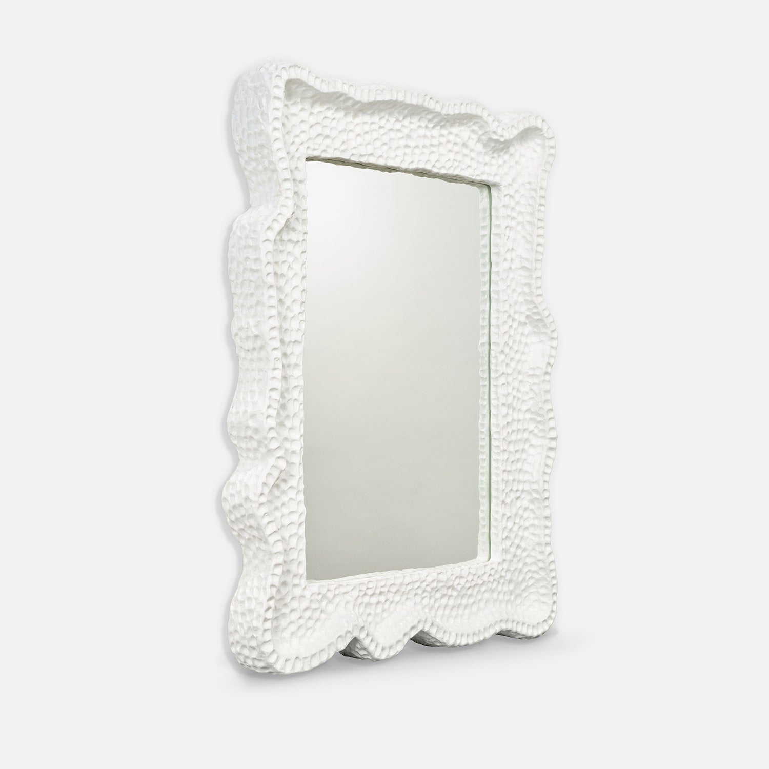 Decorative mirror with a textured white frame on a light gray background