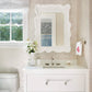 Bathroom with white vanity, mirror, and toilet.