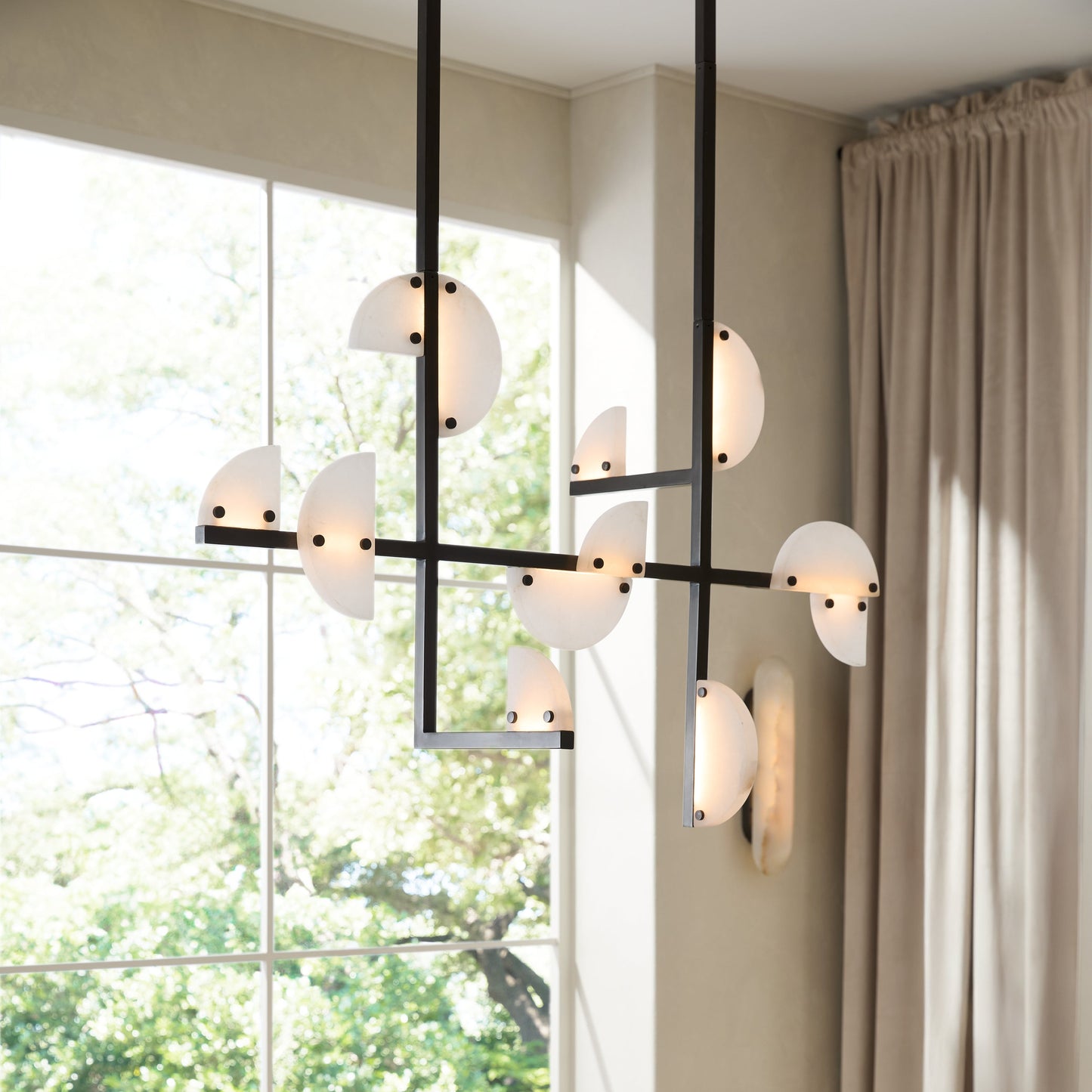 Modern chandelier hanging above a dining table with a bowl of lemons.