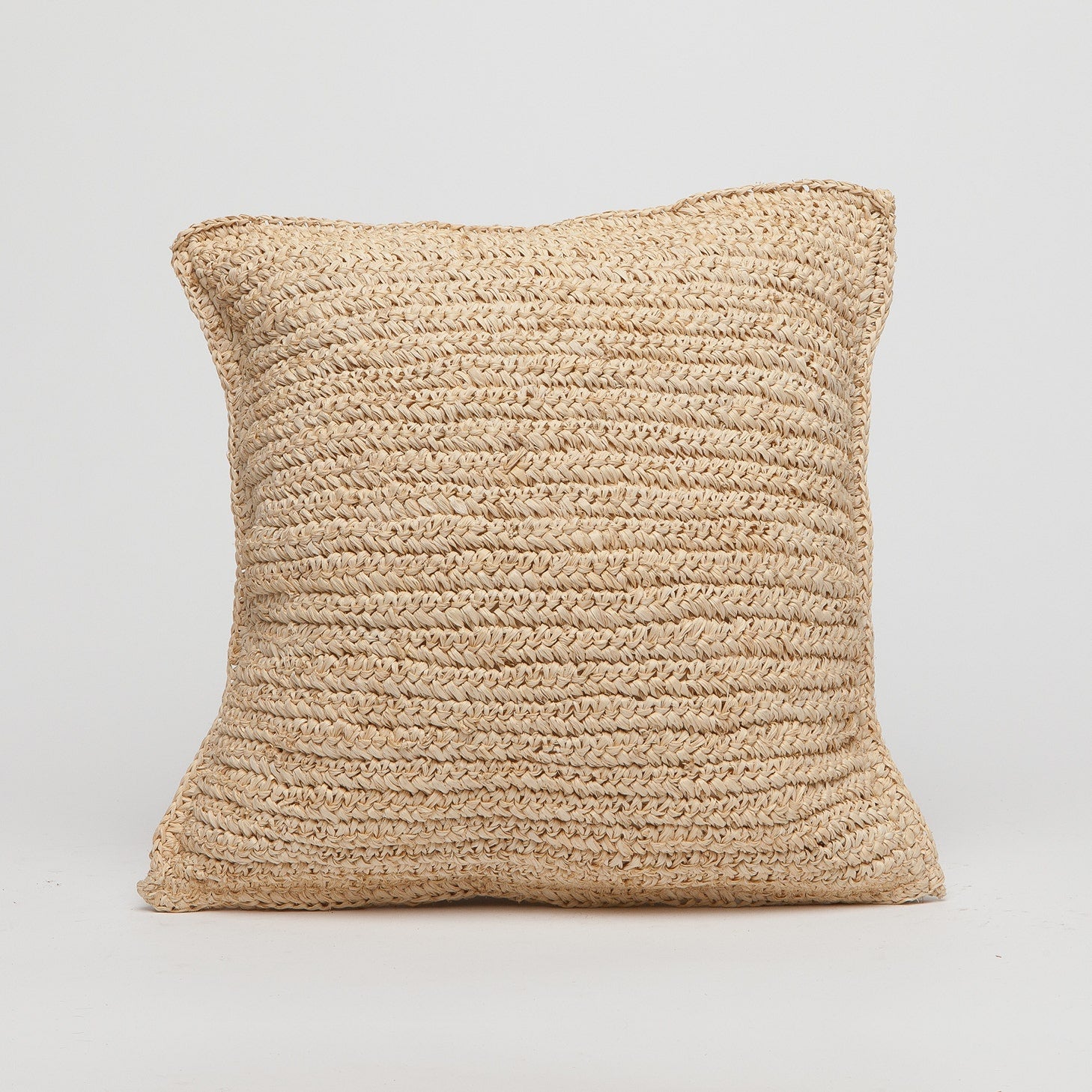 Beige woven pillow on a light gray background