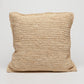A square woven throw pillow in a natural beige jute or seagrass material, shown against a plain light gray background.