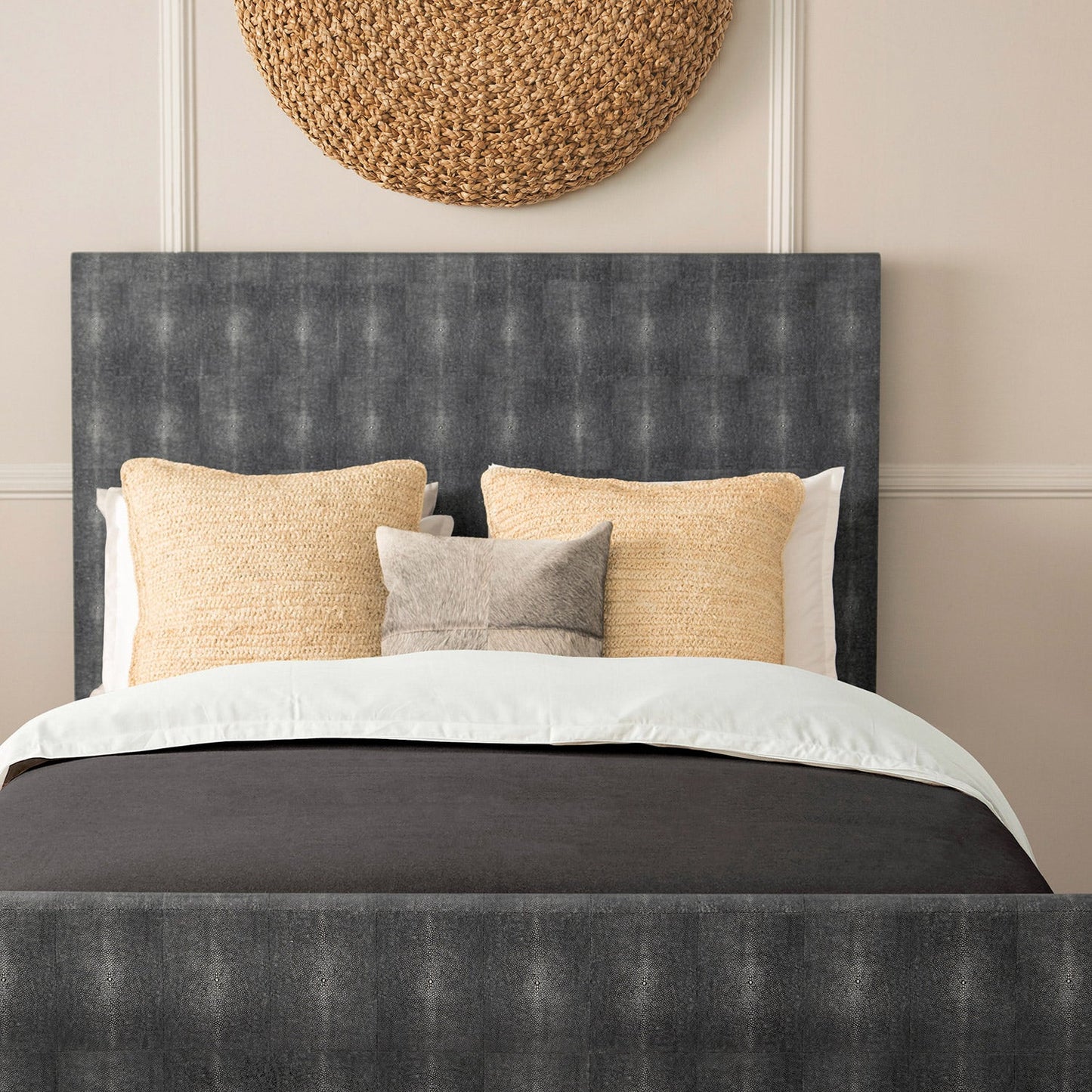 a set of raffia pillows styled on a bed