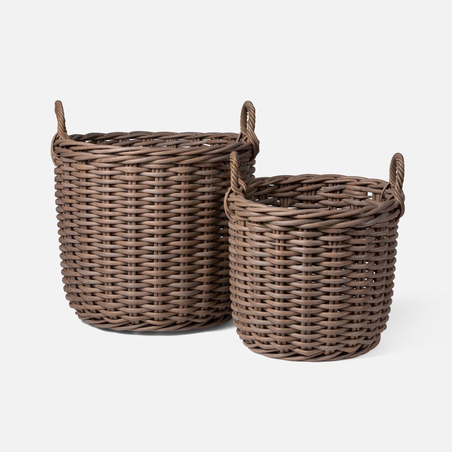 Two wicker baskets with handles on a white background