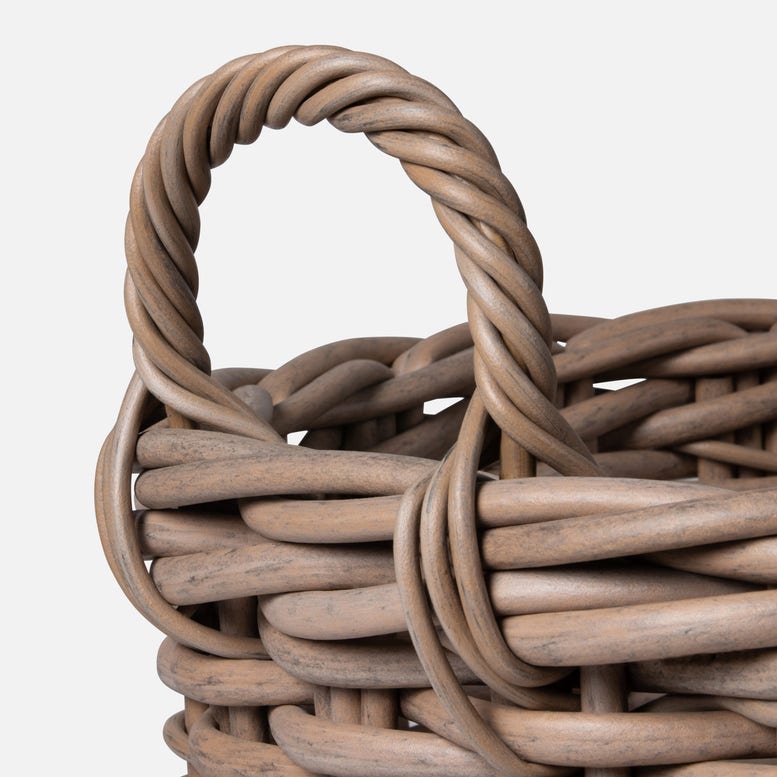 Close-up of a woven basket with a handle on a light gray background