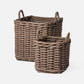 Two wicker baskets with handles on a white background