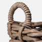 Close-up of a woven basket with a handle on a white background