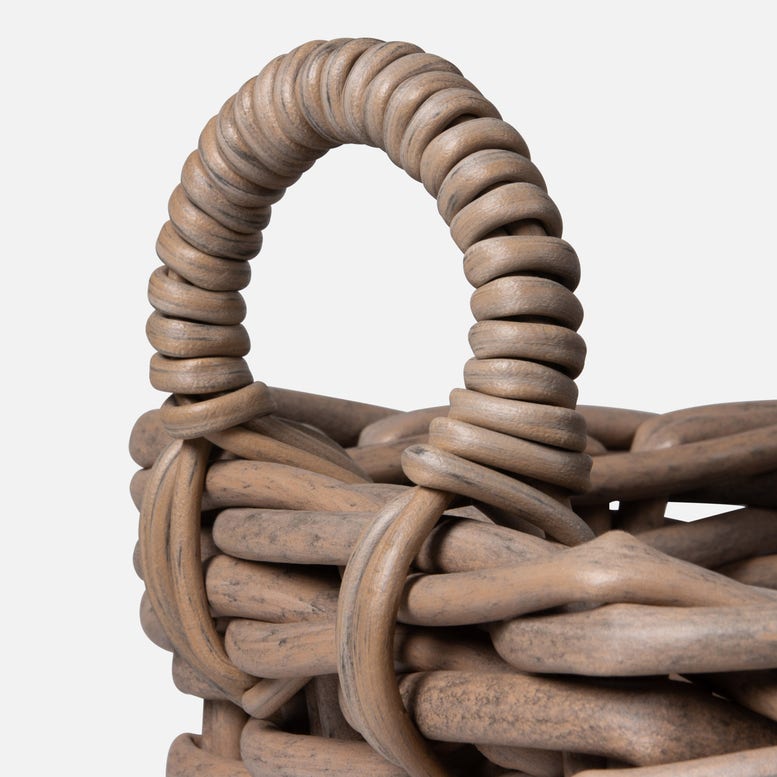 Close-up of a woven basket with a handle on a white background
