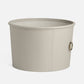 light gray round storage basket with a handle on a white background