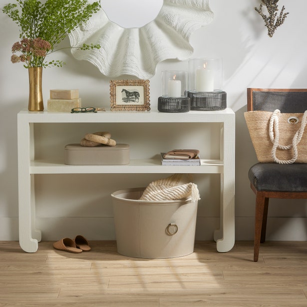 White console table with decorative items in a room setting