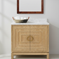 Bathroom vanity with marble countertop, wooden mirror, and decorative basket. (bixby and bradley