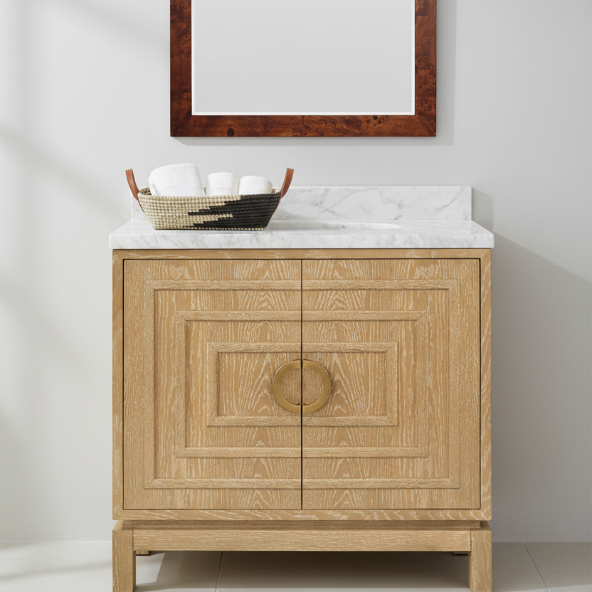 Bathroom vanity with marble countertop, wooden mirror, and decorative basket. (bixby and bradley