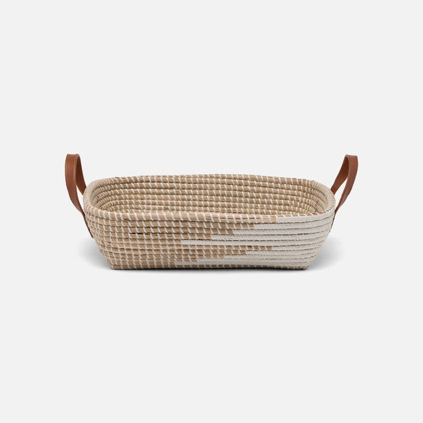 Woven basket with leather handles on a light gray background
