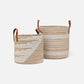 Two woven baskets with leather handles on a white background