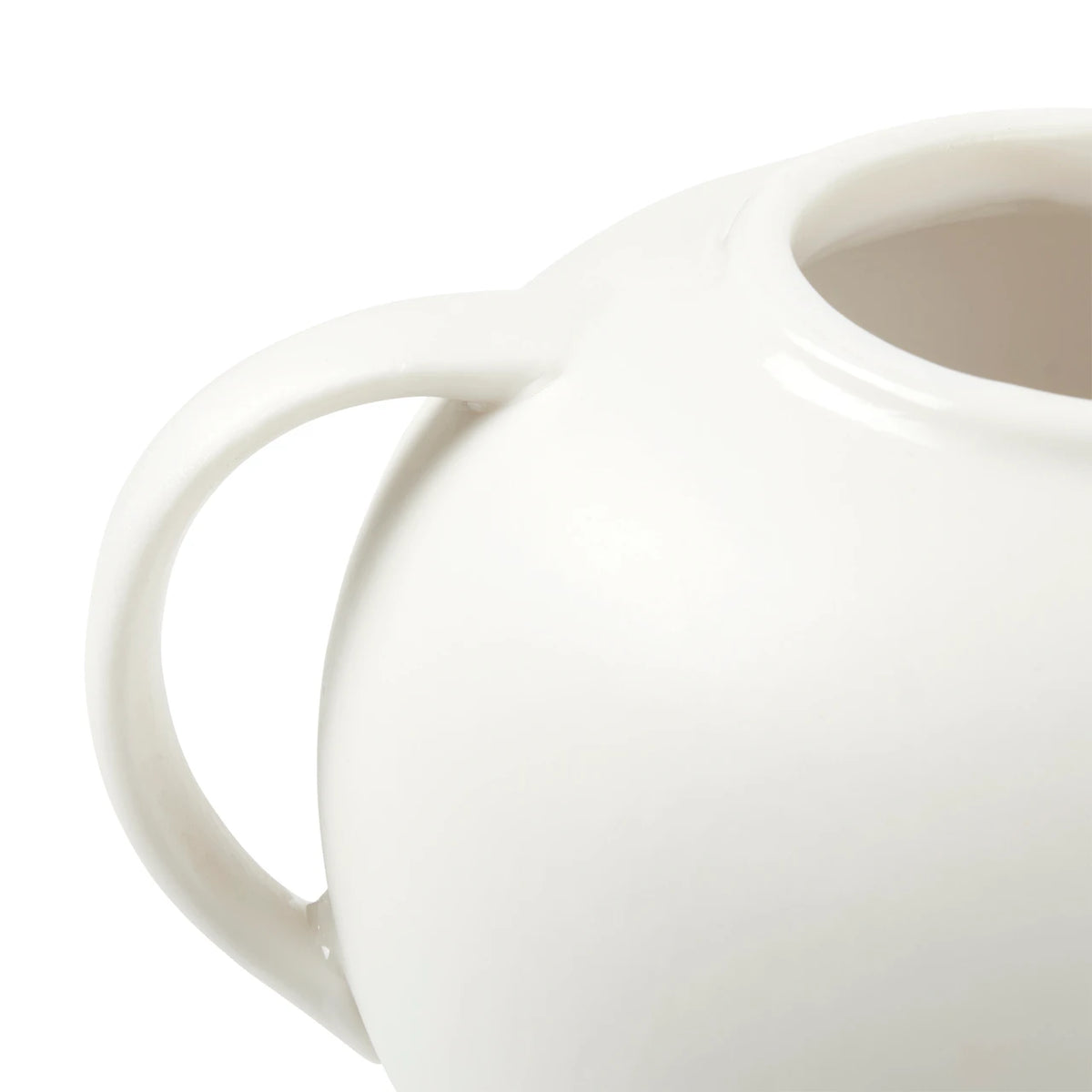 Close-up of a glossy white ceramic pitcher with a rounded body and curved handle against a white background.