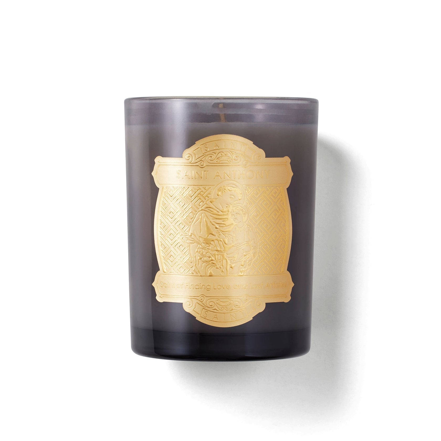 Candle with gold embossed design on a dark glass container against a white background