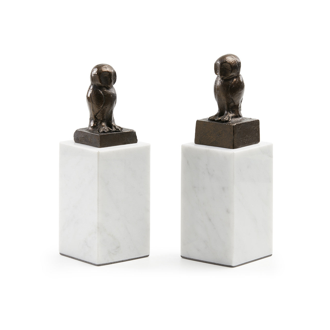 Two bronze owl sculptures on marble bases against a white background