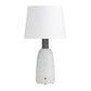 Table lamp with a white shade and textured white base on a white background