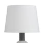A table lamp with a large white tapered drum shade, a dark gray ribbed neck, and a white marble base, shown against a plain white background.