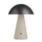Table lamp with black dome shade and beige base on a white background