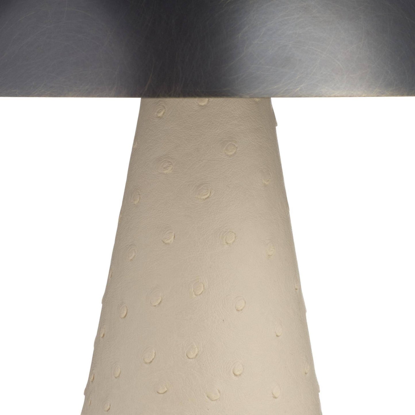 Close-up of a lamp with a metallic base and beige lampshade on a white background