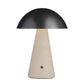 Table lamp with black dome shade and beige base on a white background