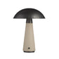 Table lamp with black dome shade and beige cylindrical base on a white background