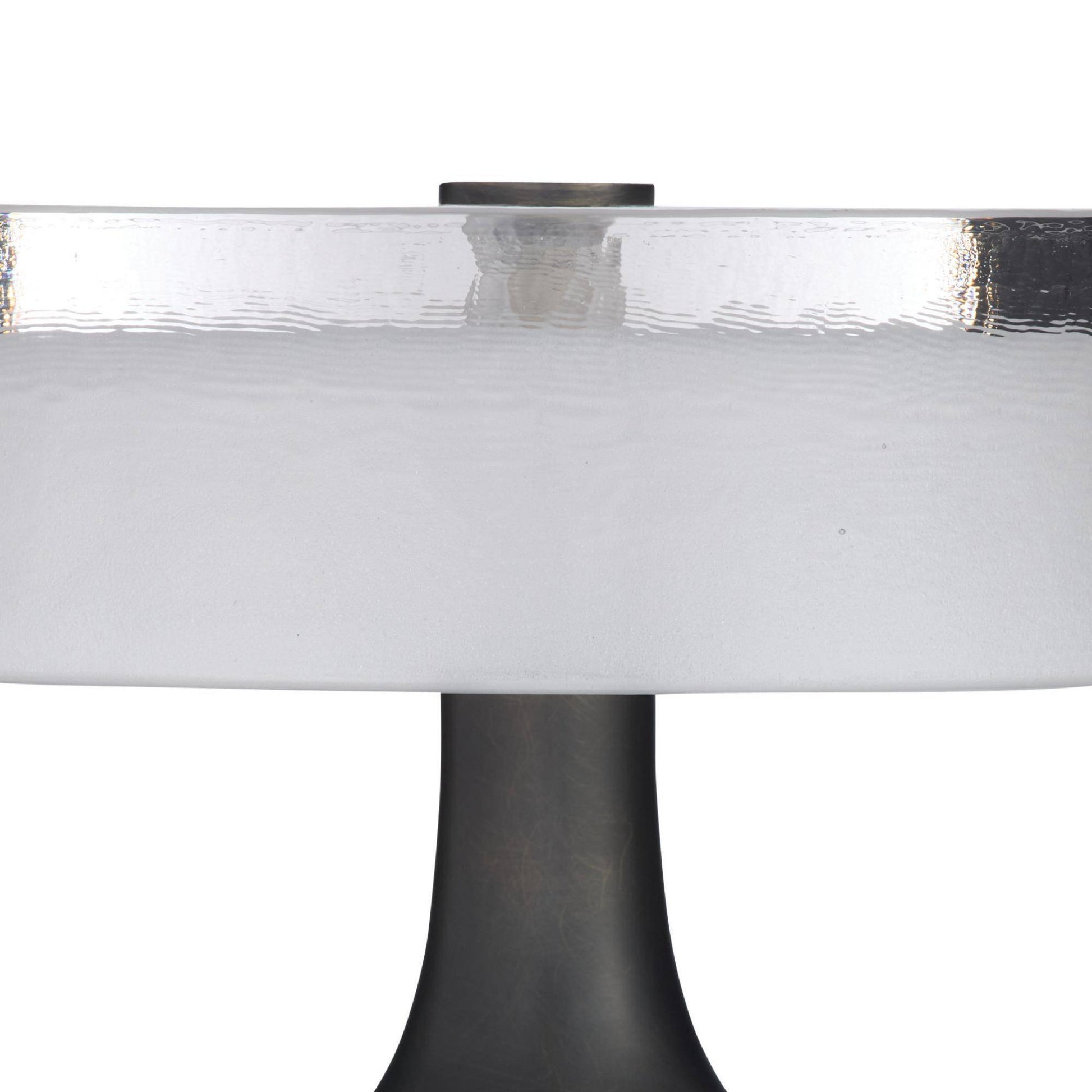 Close-up of a round glass table with a black base on a white background