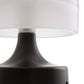 Close-up of a lamp with a white shade and black base on a white background