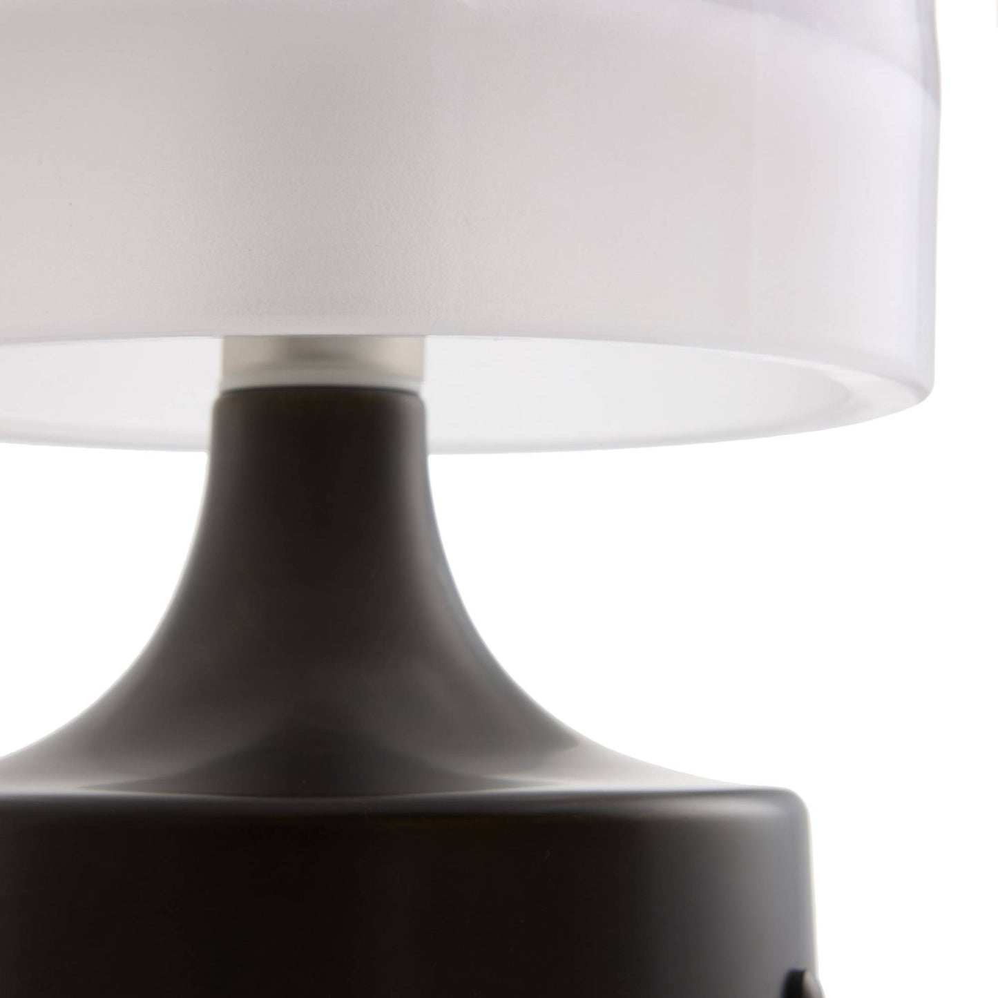 Close-up of a lamp with a white shade and black base on a white background