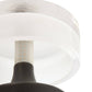 Close-up of a light fixture with a white shade and black base on a white background
