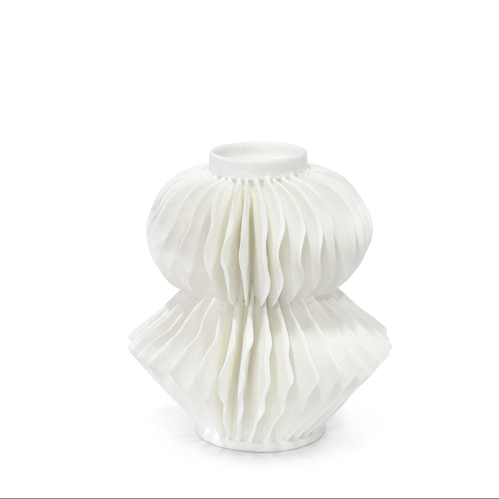 A white ceramic vase with a sculptural, pleated, accordion-like textured design, shown against a seamless white background.