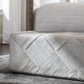 Patterned ottoman on a wooden floor with a blurred background