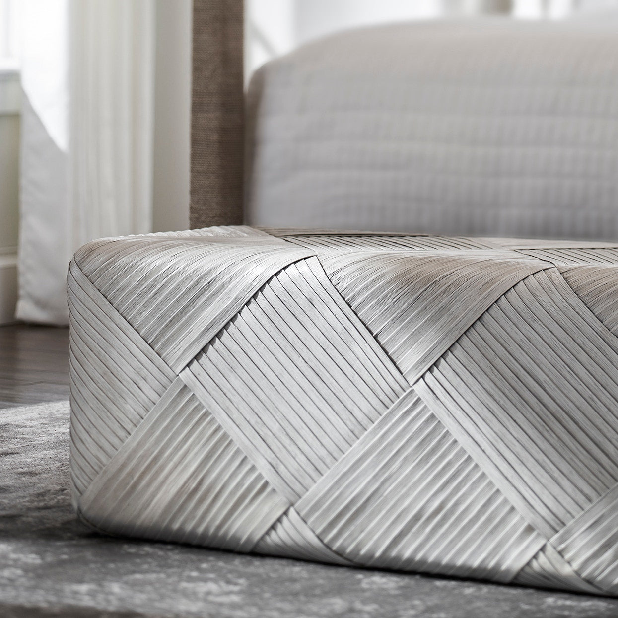 Patterned ottoman on a wooden floor with a blurred background