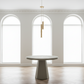 Modern dining table in a room with arched windows and a chandelier.