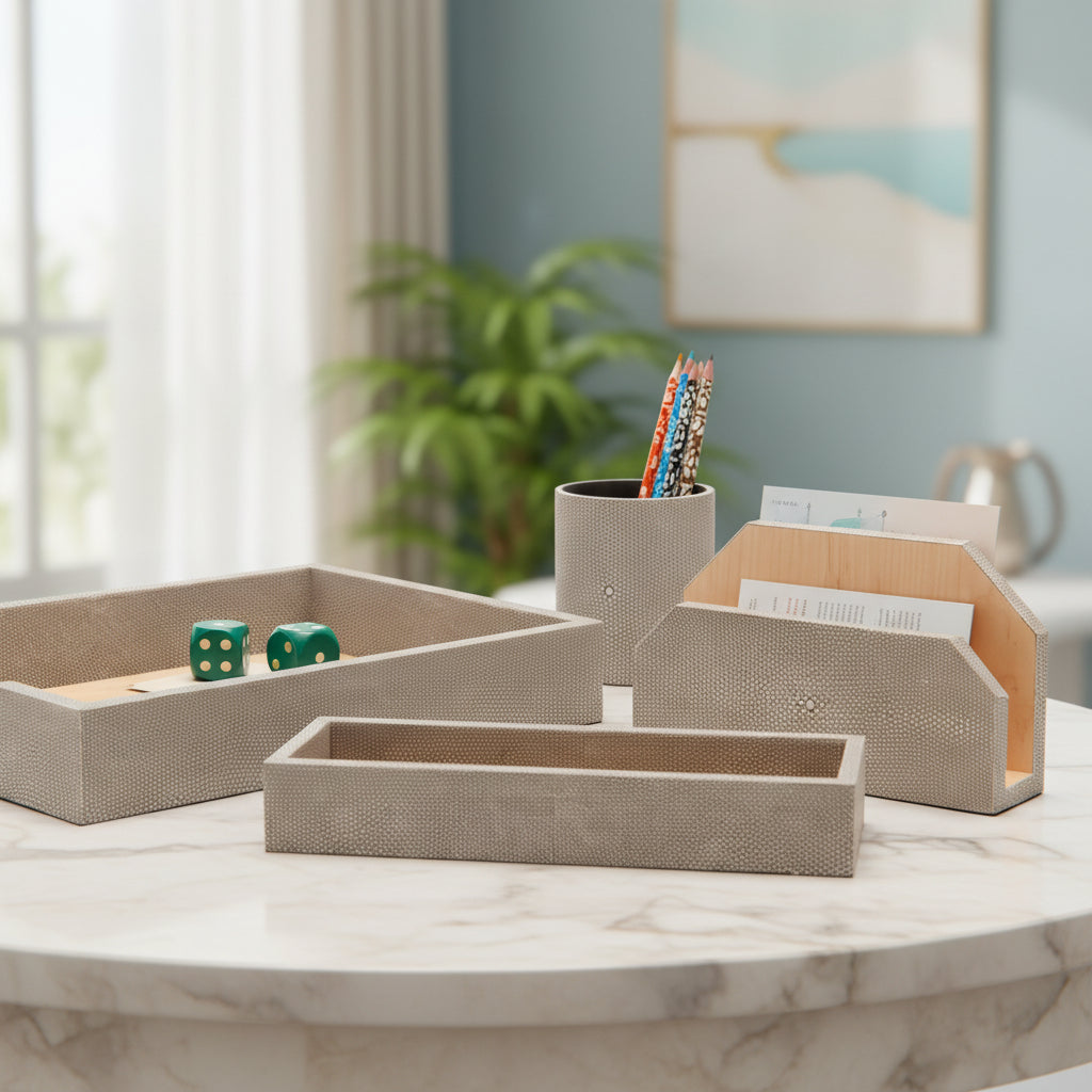 A set of minimalist desk accessories made from textured gray shagreen and natural light wood, including a tray, a pencil holder, and two small boxes, arranged on a clean white background.