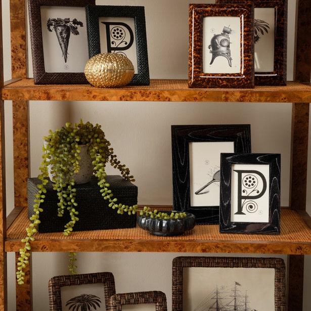 Wooden shelf with decorative items including framed pictures and a gold ornament.