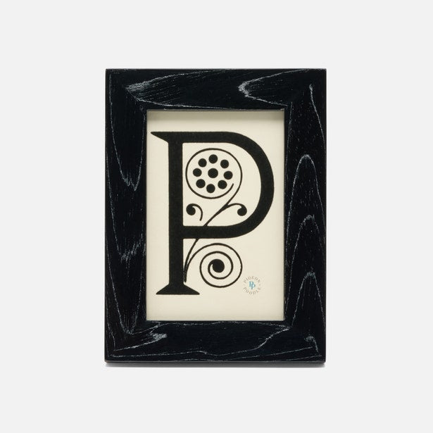 Decorative letter 'P' in a black frame on a white background