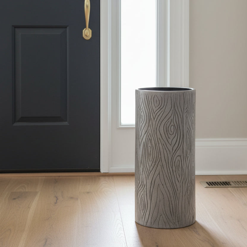 A tall, cylindrical ceramic vase with a textured wood grain pattern in gray and black, shown on a light gray background.