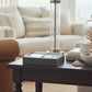 A silver-finished rectangular card tray holding playing cards, photographed in a living room.