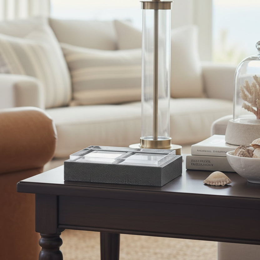 A silver-finished rectangular card tray holding playing cards, photographed in a living room.