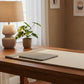 A beige rectangular desk mat with textured gray side borders and a matching gray striped rectangular pad, shown on a light gray background with a small black-handled scissors prop.