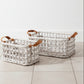 Two woven rectangular storage baskets in a light natural fiber with tan leather handles, photographed on a clean white studio background.