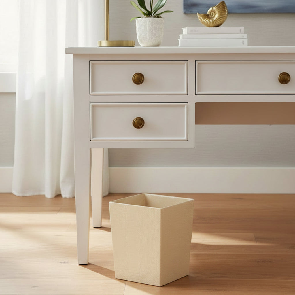A rectangular metallic gold wastebasket with a textured, shimmering finish and a black interior, shown on a clean white background.