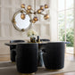 Modern dining room with black chairs, a round mirror, and a chandelier.