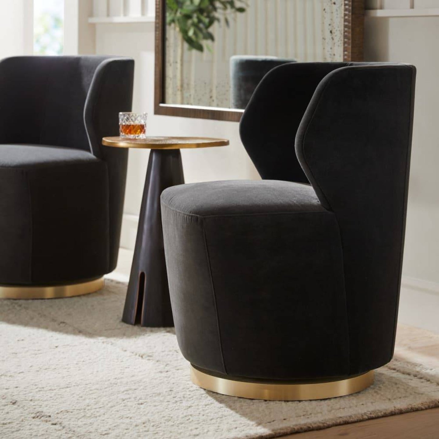 Modern dark gray upholstered chairs with gold bases in a living room setting.