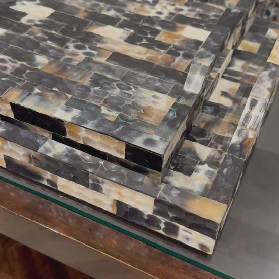 hammered horn trays stacked in a showroom