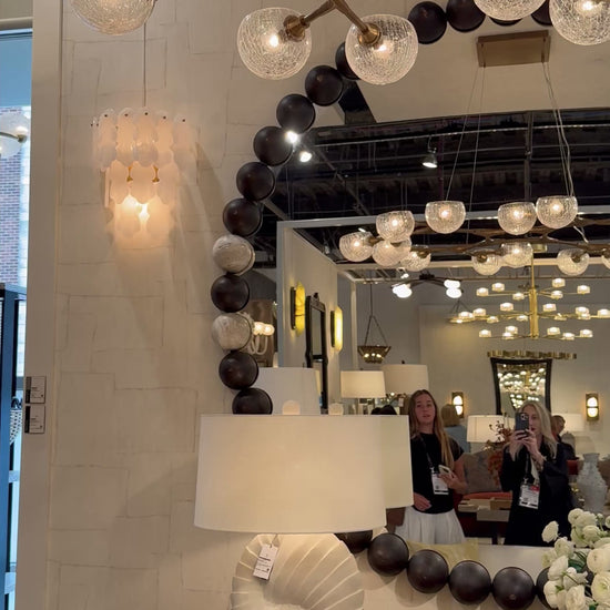 video of a showroom showcasing a wooden bead large round mirror