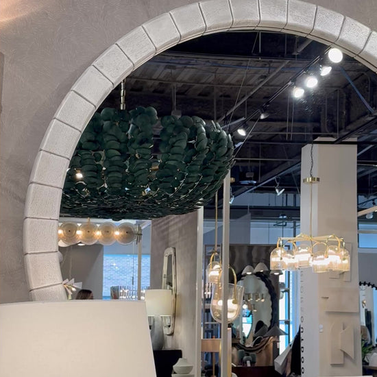 gray large round mango wood mirror in a showroom