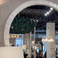 gray large round mango wood mirror in a showroom